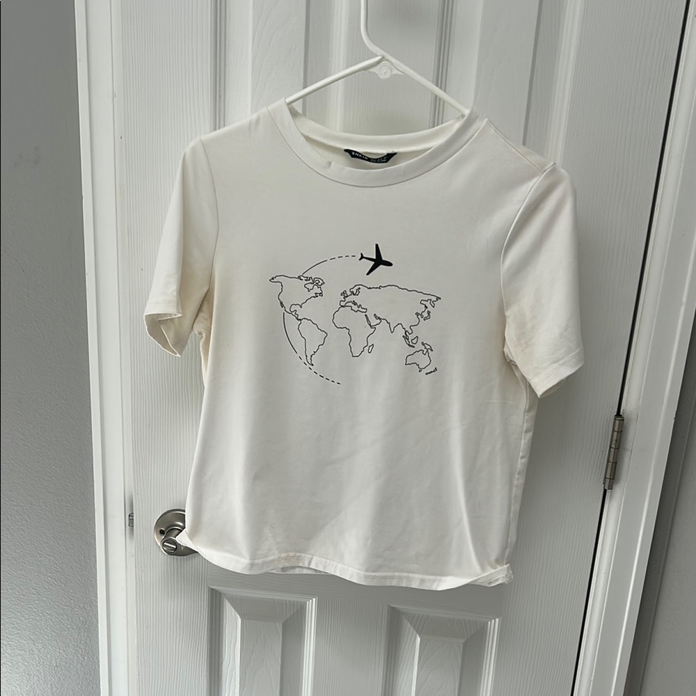 White Graphic Tee with World Map and Airplane Design